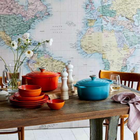 Le Creuset Taste Adventure Fernwehküche gedecker Tisch vor Weltkarte